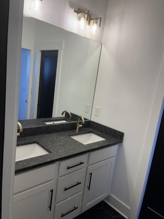 bathroom featuring tile patterned flooring, double vanity, and a sink