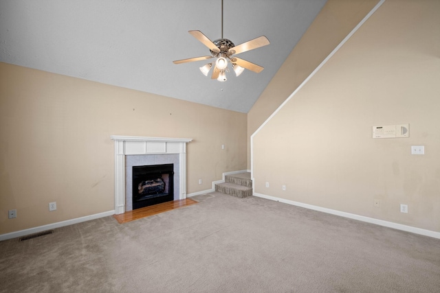 unfurnished living room featuring a ceiling fan, visible vents, baseboards, a tiled fireplace, and carpet flooring