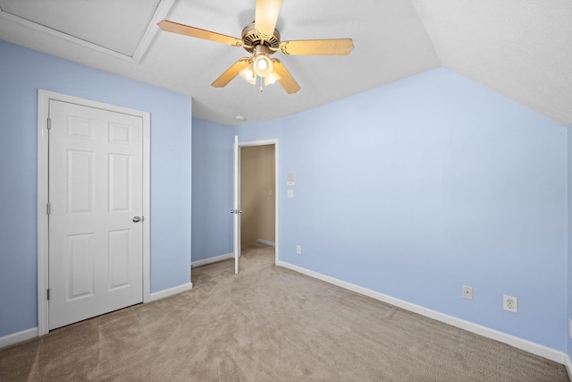 unfurnished bedroom with lofted ceiling, carpet, baseboards, and ceiling fan