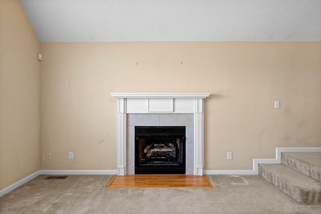 details featuring visible vents, a fireplace, baseboards, and carpet