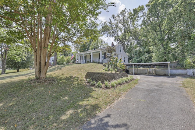 view of front of property with a front lawn, covered porch, and driveway