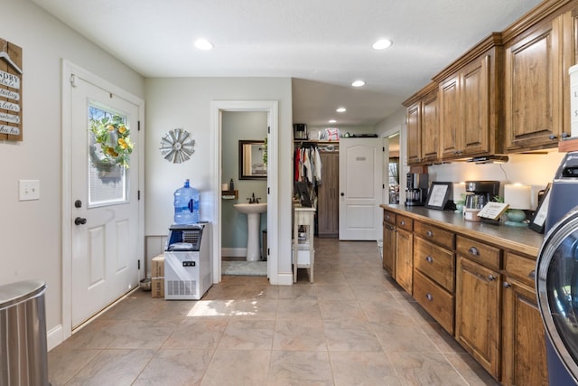 kitchen featuring brown cabinetry, recessed lighting, baseboards, and a sink