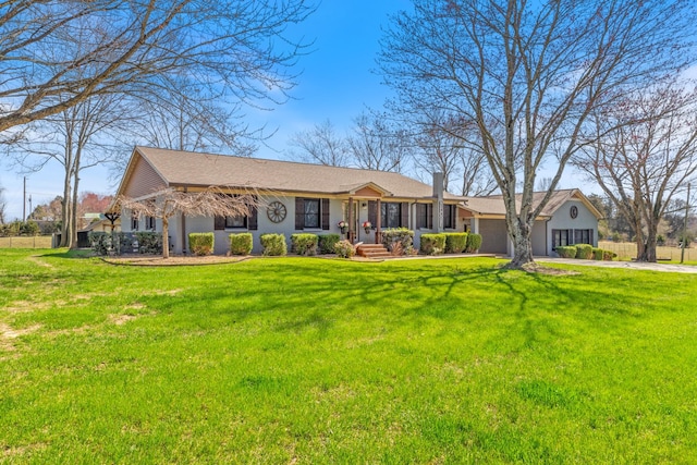 view of front of property featuring a front yard, an attached garage, and driveway