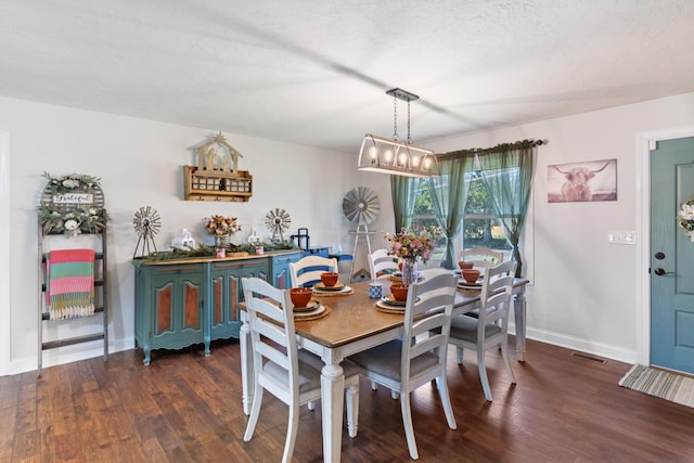 dining area with visible vents, baseboards, a notable chandelier, and wood finished floors