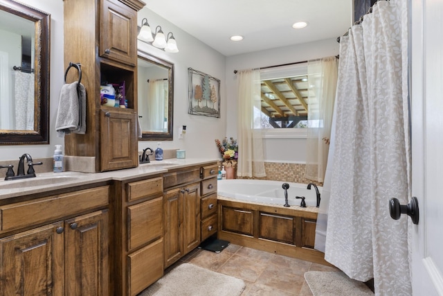 bathroom with a bath, recessed lighting, double vanity, and a sink