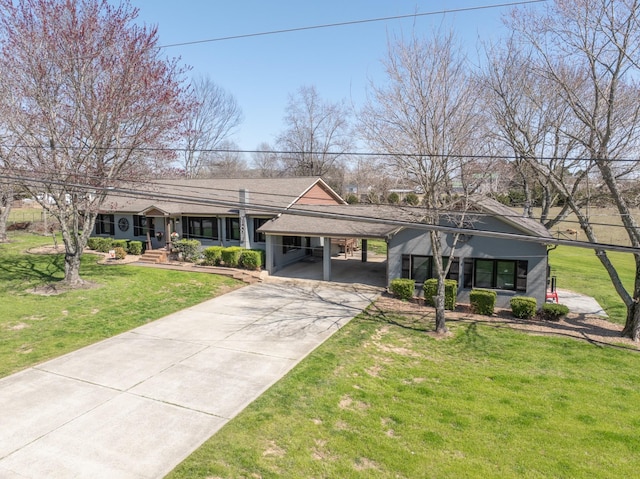 view of front of house featuring driveway, an attached carport, and a front yard