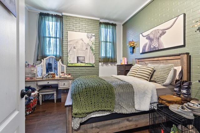 bedroom featuring wood finished floors, multiple windows, brick wall, and ornamental molding