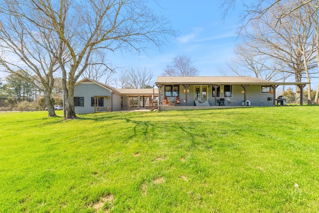 back of property with a carport, covered porch, and a lawn