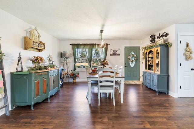 dining space with baseboards and dark wood-type flooring