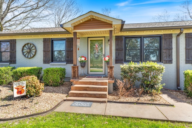 view of front of property featuring brick siding and a shingled roof