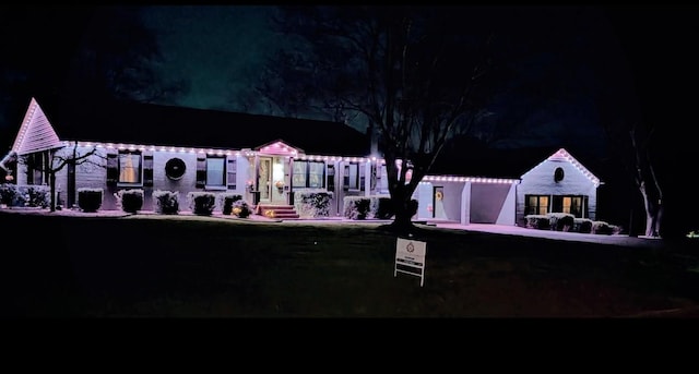 back of house at twilight with a garage and concrete driveway