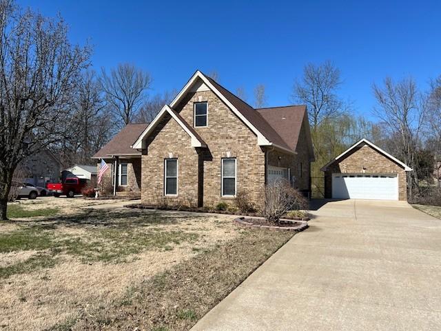 view of front of home featuring brick siding and concrete driveway