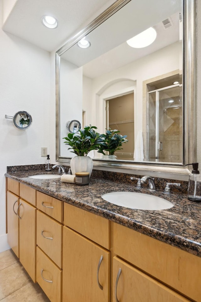 full bathroom with a shower stall, double vanity, visible vents, and a sink