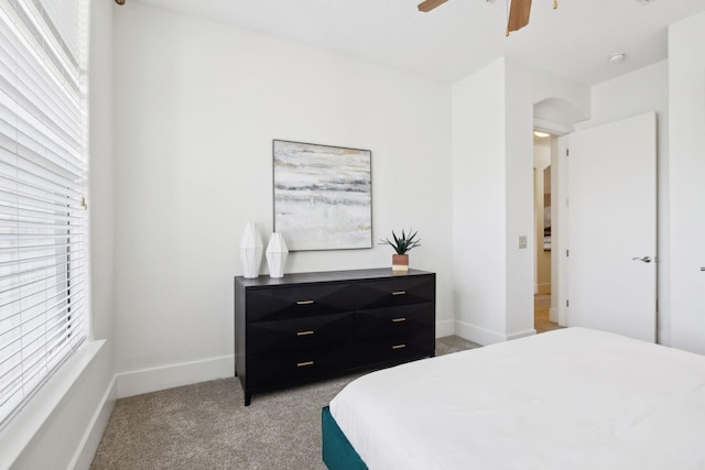 bedroom with light colored carpet, a ceiling fan, and baseboards