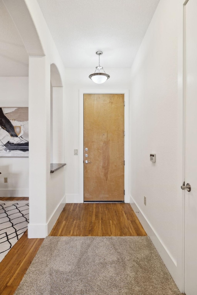 entryway with baseboards and wood finished floors