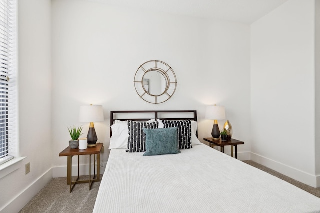 carpeted bedroom featuring multiple windows and baseboards