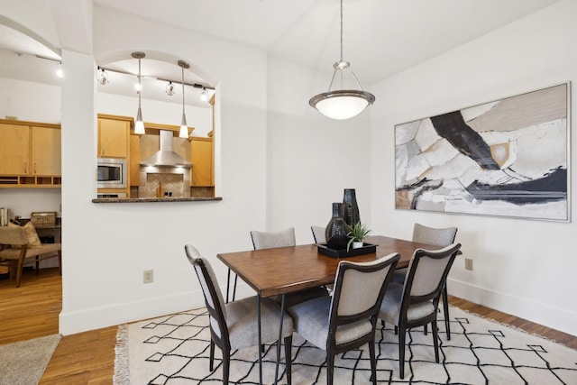 dining space with baseboards and light wood-type flooring