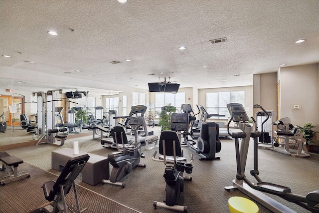 workout area with recessed lighting, visible vents, and a textured ceiling