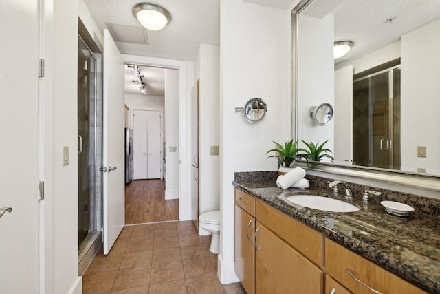 full bathroom featuring tile patterned flooring, vanity, a stall shower, and a textured ceiling