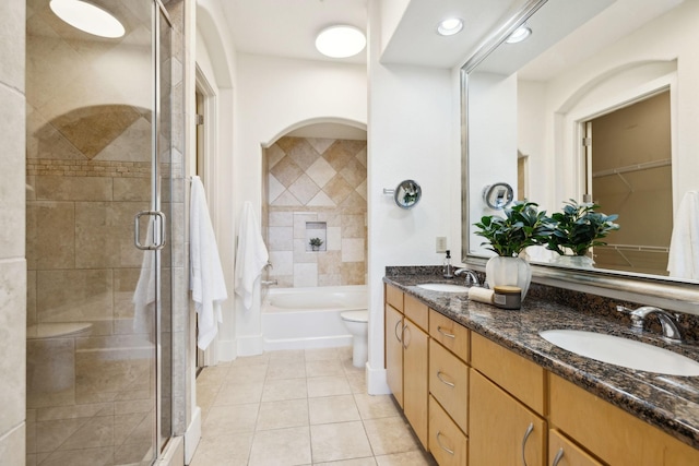 full bath with a sink, tiled shower, and toilet