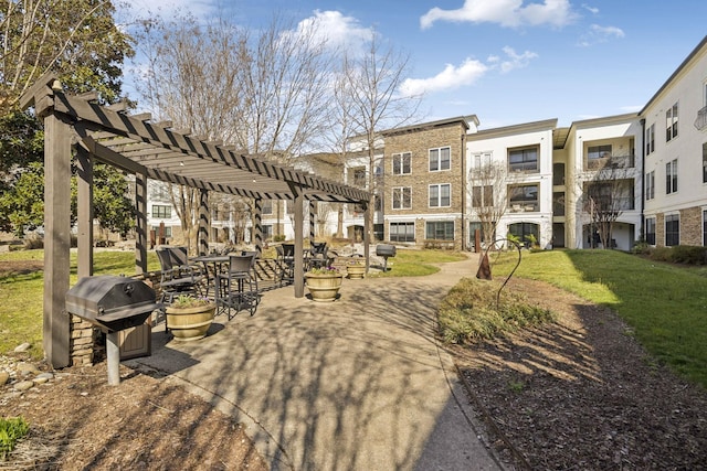 view of property's community featuring a yard, a patio area, and a pergola