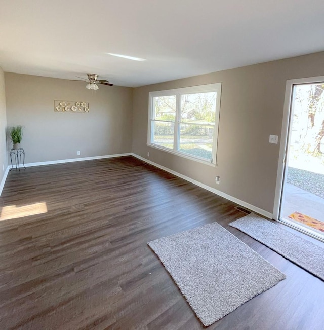 interior space featuring dark wood finished floors, plenty of natural light, and a ceiling fan