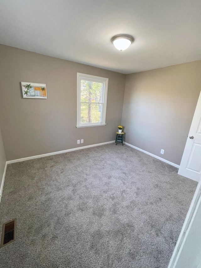 empty room featuring visible vents, baseboards, and carpet flooring