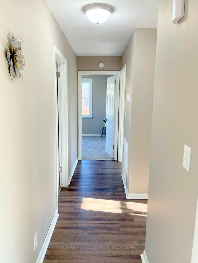 hallway featuring baseboards and wood finished floors