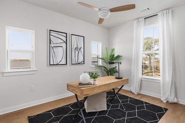 office space with visible vents, baseboards, wood finished floors, and a ceiling fan