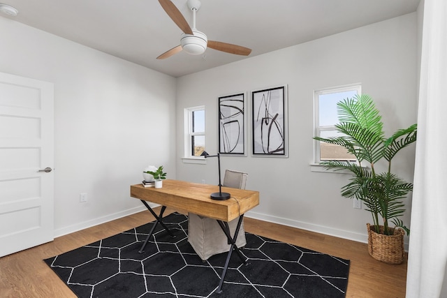 office with baseboards, wood finished floors, and a ceiling fan