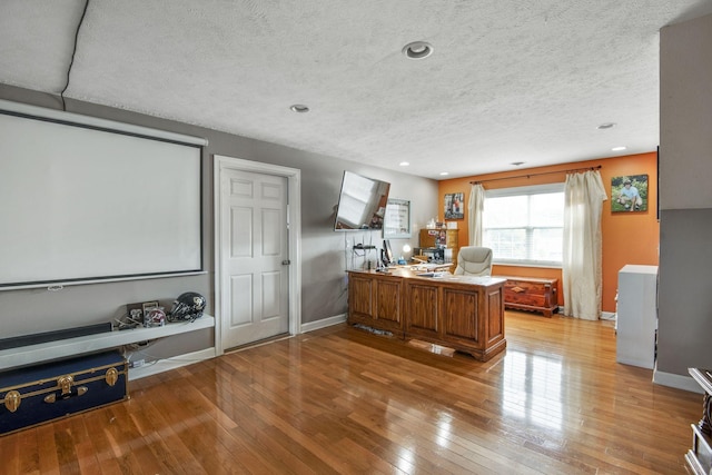 home office featuring recessed lighting, light wood-style floors, baseboards, and a textured ceiling