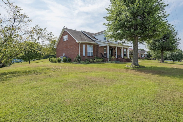 view of front facade featuring a front lawn, covered porch, and brick siding