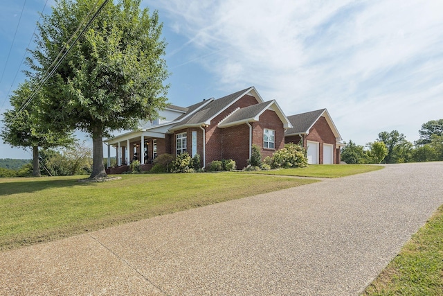 view of front of home featuring a garage, driveway, brick siding, and a front yard