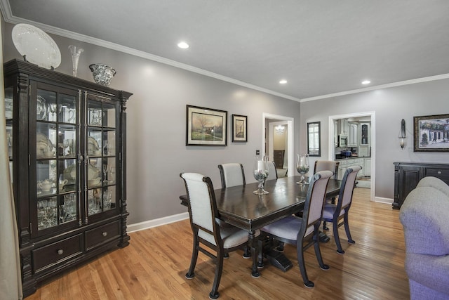 dining area with recessed lighting, light wood-style flooring, crown molding, and baseboards