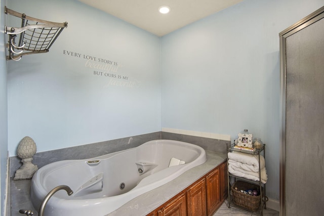 bathroom with recessed lighting and a tub with jets