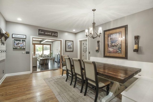 dining space featuring recessed lighting, baseboards, a notable chandelier, and hardwood / wood-style flooring