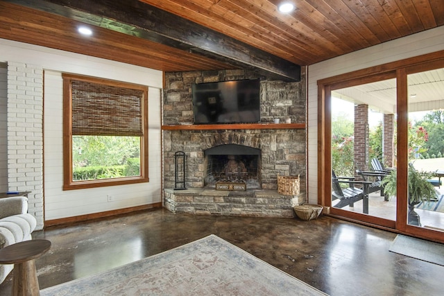 unfurnished living room with beam ceiling, finished concrete floors, recessed lighting, a stone fireplace, and wood ceiling