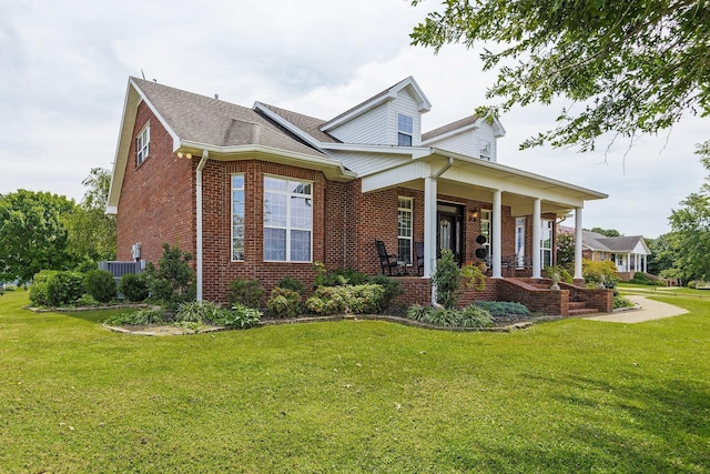 view of front facade with a front lawn, cooling unit, covered porch, and brick siding