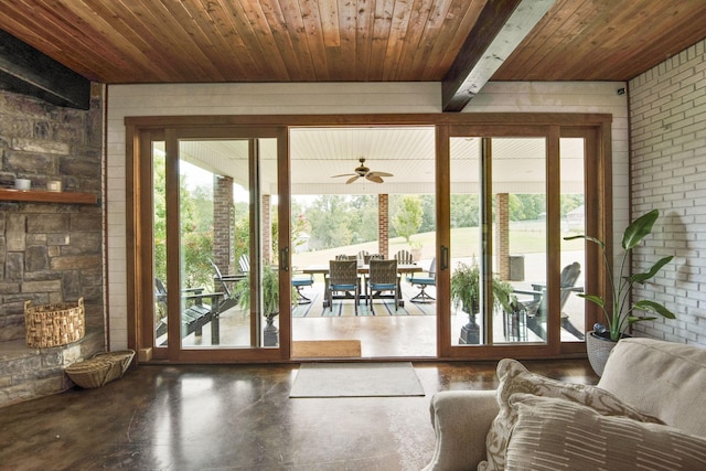 entryway with wooden ceiling, brick wall, concrete flooring, and a ceiling fan