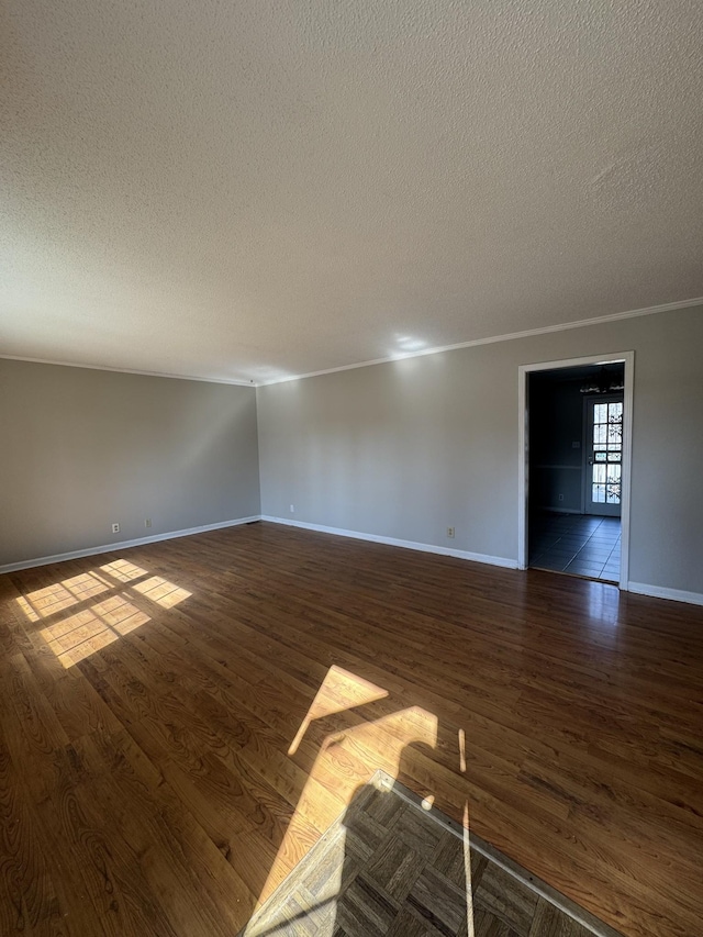 spare room with baseboards, dark wood-type flooring, and a textured ceiling