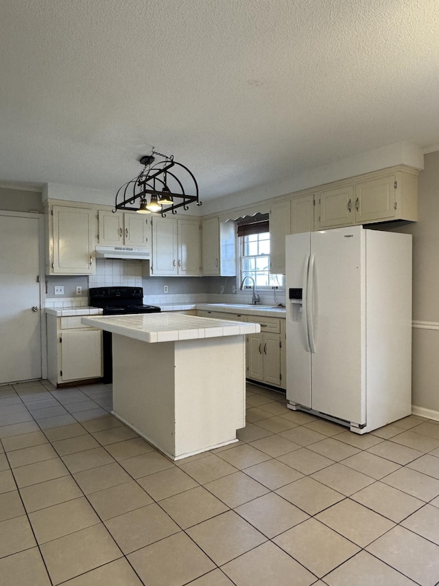 kitchen featuring a kitchen island, light tile patterned flooring, tile counters, white refrigerator with ice dispenser, and under cabinet range hood