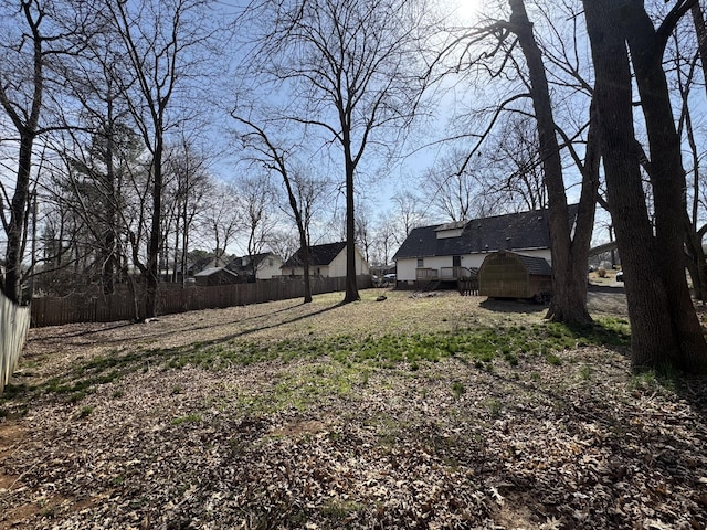 view of yard featuring an outdoor structure and fence