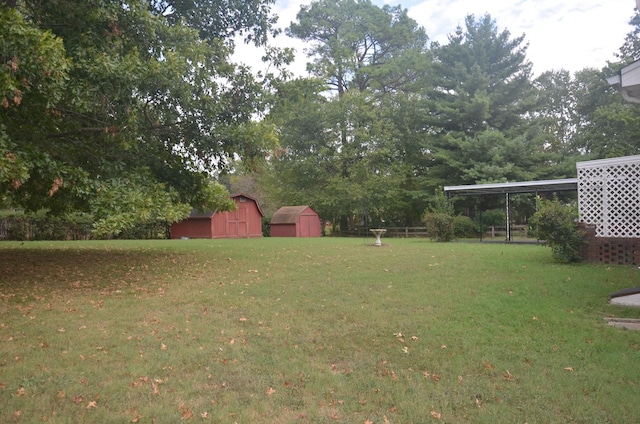 view of yard with an outbuilding, a shed, and an attached carport