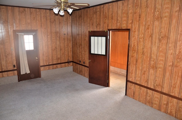 spare room with wooden walls, ceiling fan, and carpet floors