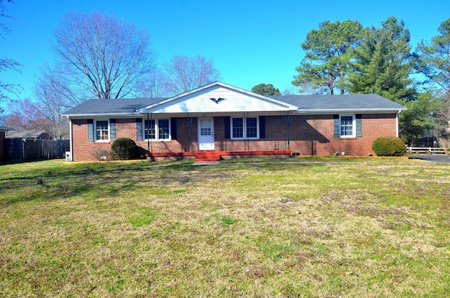 single story home featuring brick siding, a front lawn, and fence