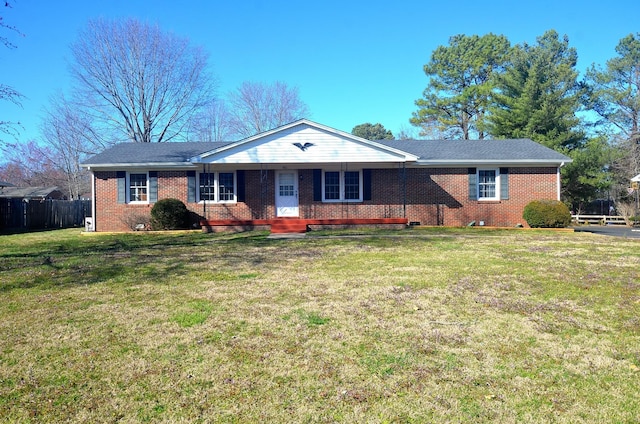 single story home featuring a front lawn, fence, and brick siding