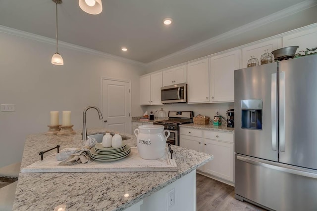 kitchen with ornamental molding, appliances with stainless steel finishes, wood finished floors, white cabinets, and a sink