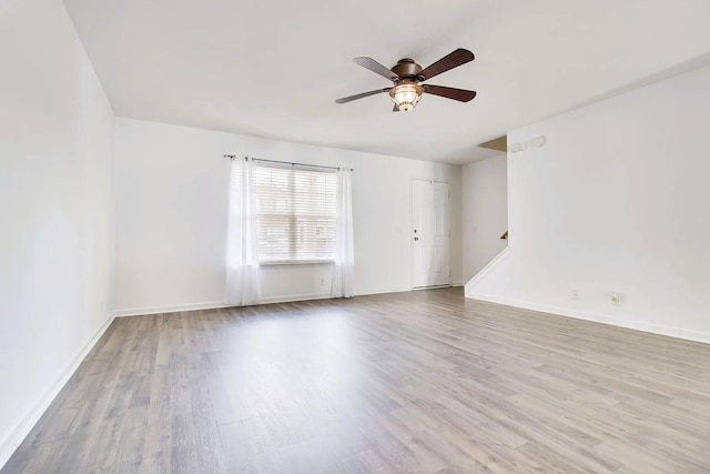 unfurnished room with baseboards, wood finished floors, and ceiling fan