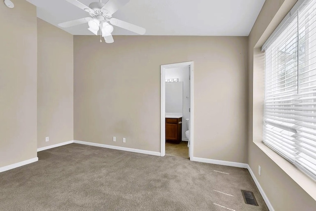 empty room featuring a ceiling fan, a healthy amount of sunlight, baseboards, and light carpet