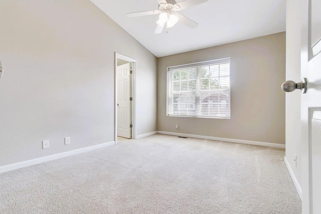 spare room with baseboards, light colored carpet, ceiling fan, and vaulted ceiling